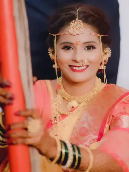 A happy bride during her wedding ceremony, her smile and bright makeup lighting up the frame.