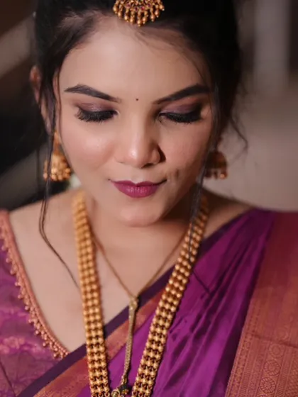 A detailed shot of the eye makeup, featuring a soft purple and brown smokey eye that complements the saree.