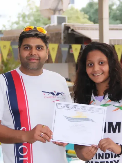 Presenting a certificate of participation. Every swimmer who puts in the effort is a winner in my book.