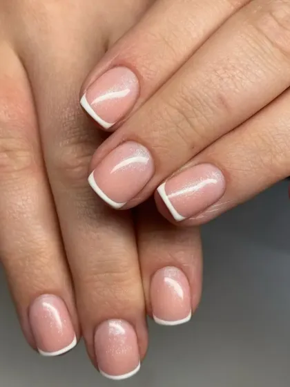 A beautiful example of a classic French manicure on short, natural square-shaped nails for a clean and professional look.