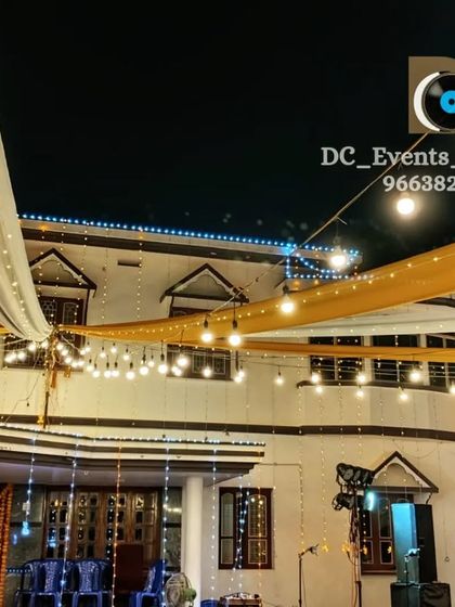 A wide view of a home decorated for a celebration, showing how we combine draped fabric canopies with string lights to transform the outdoor space.