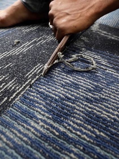 A worker carefully lays carpet tiles inside the mobile classroom. We used durable and colorful materials to create a welcoming and comfortable environment for the children.