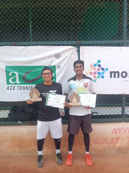 Two of our senior players showcasing their trophies after winning the Men's 1 lac doubles tournament, proving our training extends to high-level competition.