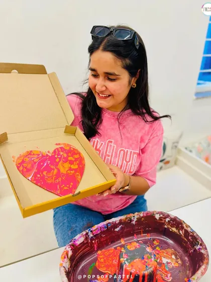 Admiring the final result. This participant smiles as she looks at the unique patterns on her fluid art heart, created just moments before.