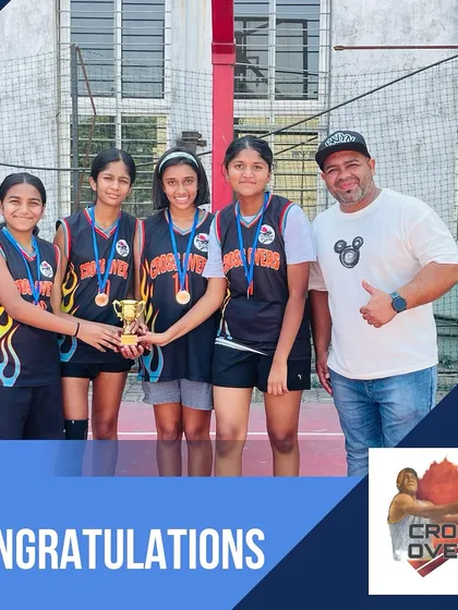 A coach stands proudly with the runner-up girls' team. We believe champions are made when talented individuals come together as one.