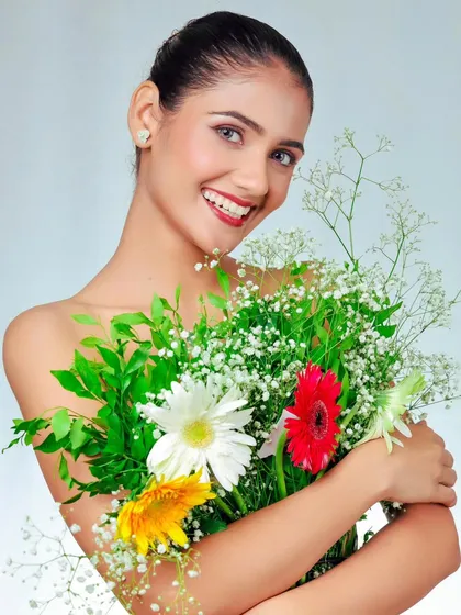 A fresh and beautiful portrait with a bouquet of flowers. The model's bright smile and the colorful flowers create a very positive and vibrant image.
