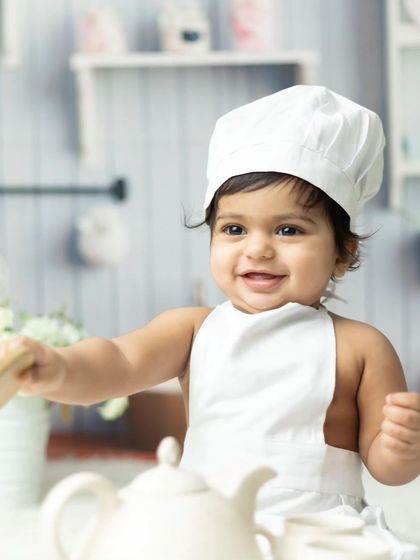 Another delightful shot of the baby chef, capturing a moment of pure, happy play.