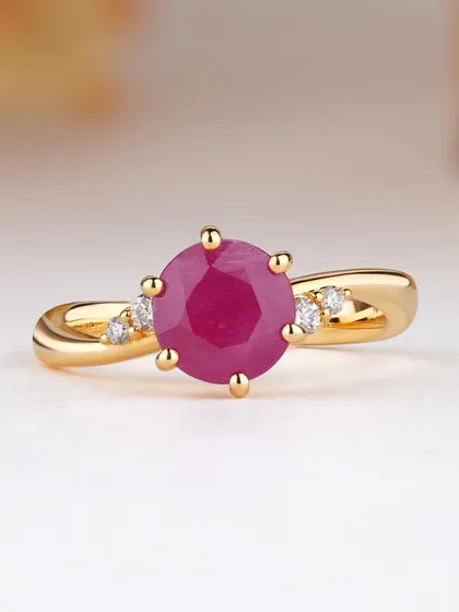 Discover the magic of gemstones. This elegant ring features a round ruby set on a gently twisted gold band, accented with small diamonds. It is a simple yet beautiful design that lets the gemstone's color truly shine.