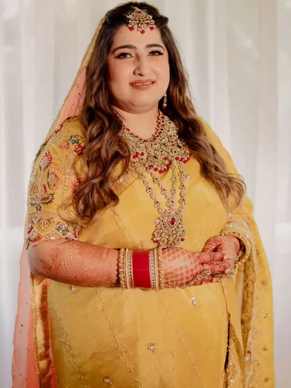 Capturing the joy of this bride's wedding ceremony. Her makeup is traditional and radiant, with warm tones and defined eyes, paired with soft waves for a look that is both classic and effortlessly beautiful.