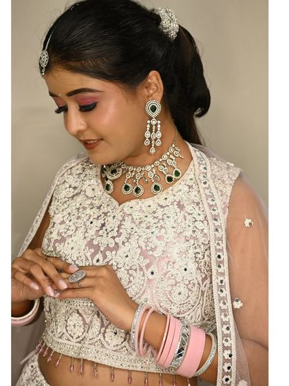 This shot highlights the detailed work on the blouse and the elegant jewellery pairing. The pink bangles add a lovely pop of color.