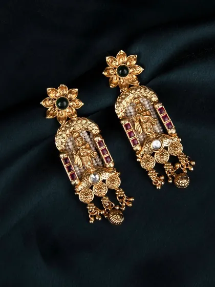 Another angle of the traditional earrings on a dark teal satin cloth, highlighting the reflection and shine of the gold.