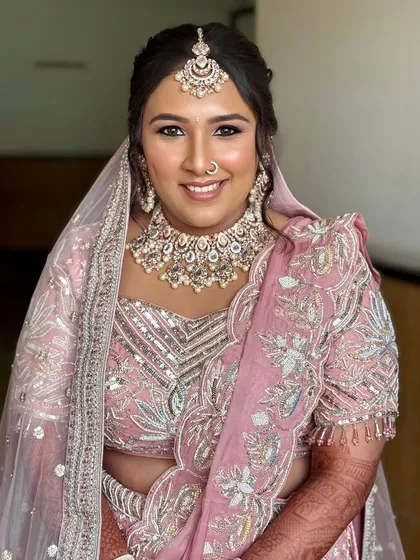 A perfect example of a modern pastel bride. This look features soft pink tones, a dewy base, and a beautifully detailed lehenga, creating a look that feels like a real-life desi Barbie.
