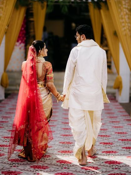 Walking away from the ceremony, hand-in-hand, this shot captures the beginning of the couple's journey, with the bride's red veil adding a pop of colour.