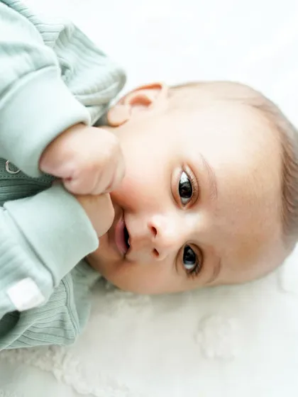 A close-up of a beautiful, wide-eyed baby. These simple, clean portraits put all the focus on your little one's expressive face and budding personality.