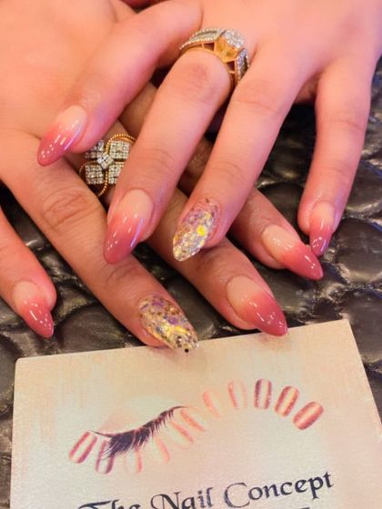 A dramatic stiletto nail set with a pink ombre base. The accent nails are covered in shattered glass-style holographic foil, creating a sharp, multi-faceted shine.