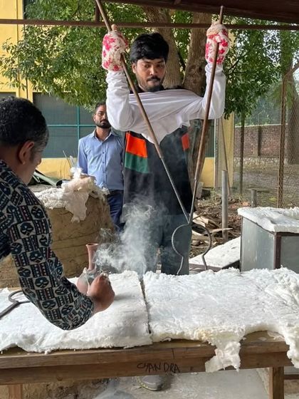 A demonstration of the horsehair Raku technique for students. The long tongs are used to safely handle the hot ceramic piece as the hair is applied.