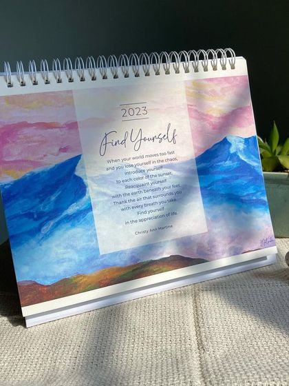 The cover of my 'Find Yourself' 2023 desk calendar. It features a collage of my mountain paintings and a short poem, setting the theme for a year of appreciation and discovery.