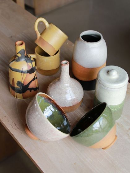 A colorful array of bowls, vases, and mugs, showcasing the students' experiments with layered glazes and contrasting clay bodies.