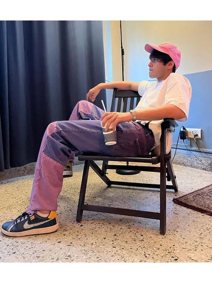 Another angle of the menswear styling for Anshuman Malhotra. The combination of the pink cap and two-tone jeans creates a cohesive look that is both on-trend and personal.