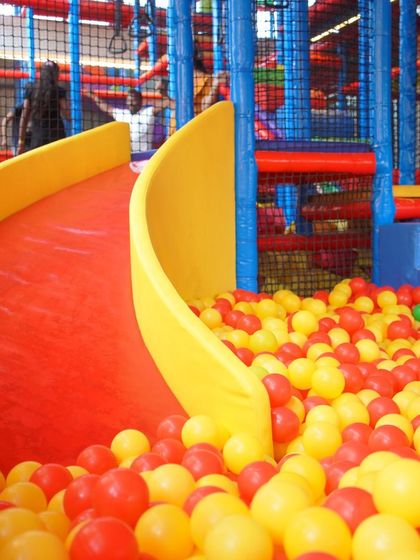 Another view of one of our exciting slides, showing how it curves into the soft landing of the ball pit. We have multiple slides to ensure the fun never stops.