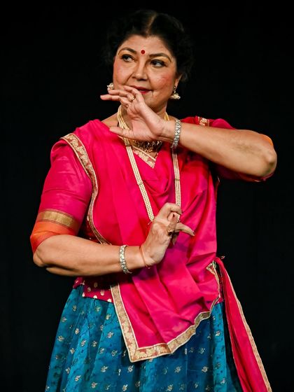 A close-up of my mother's expressive hands and face during a performance. Every mudra and glance tells a story, a testament to her decades of mastery in abhinaya.
