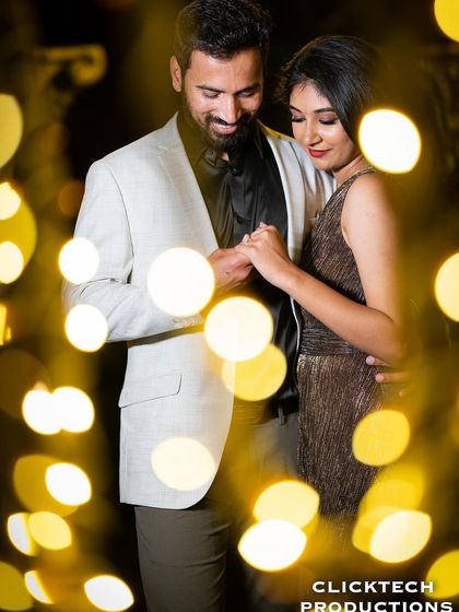 An intimate shot of a couple holding hands, framed by the beautiful bokeh of warm fairy lights, creating a romantic and artistic effect.
