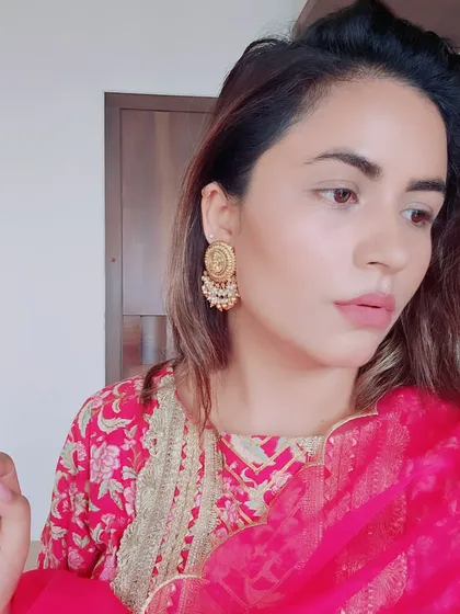 A close-up of this pink floral suit highlights the intricate gold embroidery on the neckline. I advise on choosing outfits with details that enhance the overall look and pair them with the right jewelry, like these traditional gold earrings.