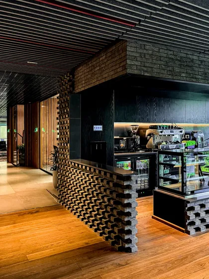 A detail of the cafe at BCG HQ, where a textured brick counter contrasts with the smooth wooden floor, highlighting our focus on material honesty.