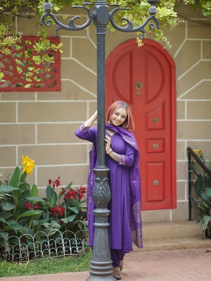 A full-length shot of the model by the lamppost and red door of our European street set.