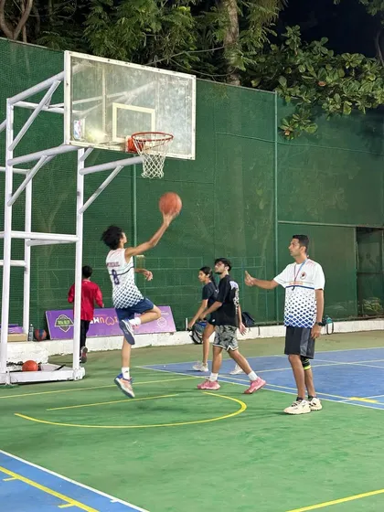 A player executes a perfect layup in practice, with a coach observing and providing guidance. This is where skills are refined.