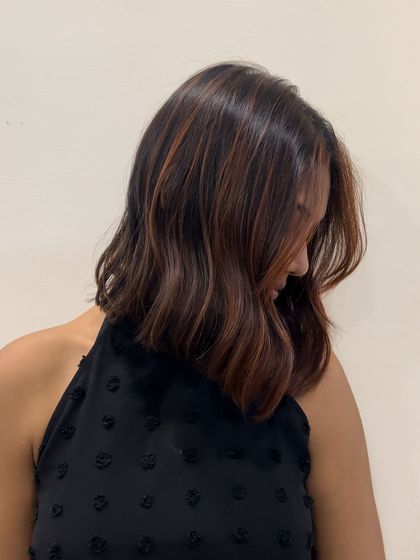 A chic bob with subtle red-toned babylights. This technique adds a hint of color and dimension without being a drastic change, perfect for a first-time color client.