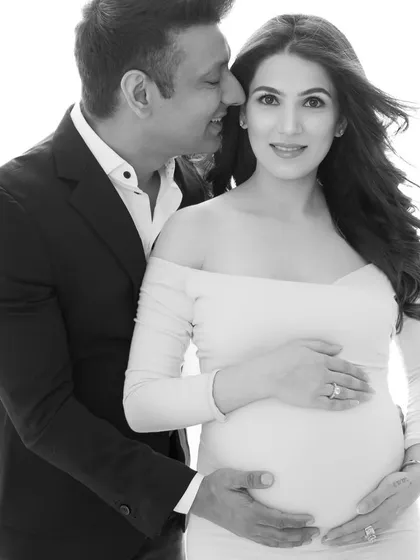 A secret whispered between partners. This black and white shot captures an intimate, candid moment, adding a touch of romance and mystery to their maternity gallery.