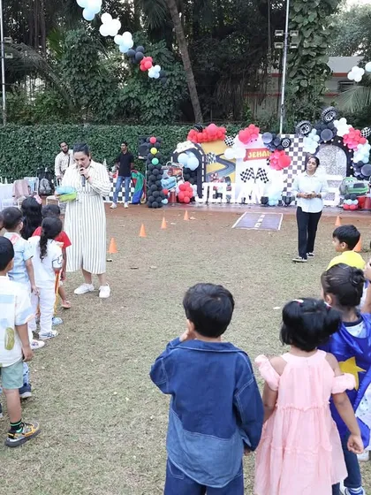 A wide shot of the outdoor party area, showing the host leading a game with the kids. I can plan parties in all kinds of venues, indoors and outdoors.