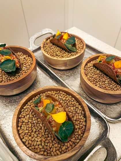 Canapé-sized mushroom tacos presented in individual bowls. These feature a fermented garlic aioli, green papaya som tam, and a truffle egg yolk gel.