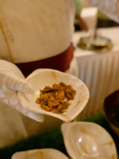 A close-up of a freshly prepared appetizer, held by one of our chefs. This showcases the final product just before it is served, highlighting the texture and freshness.