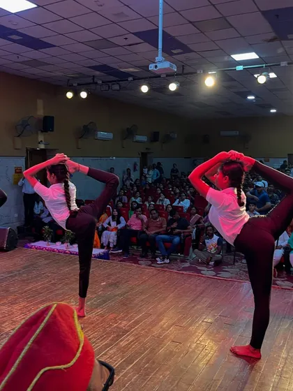 The beauty of symmetry in yoga, as two of my students hold a challenging standing split pose on stage.