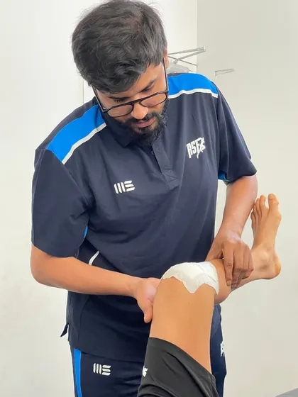 One of our physiotherapists applies McConnell taping to a client's knee, a technique used to correct patellar tracking issues and reduce pain during movement.