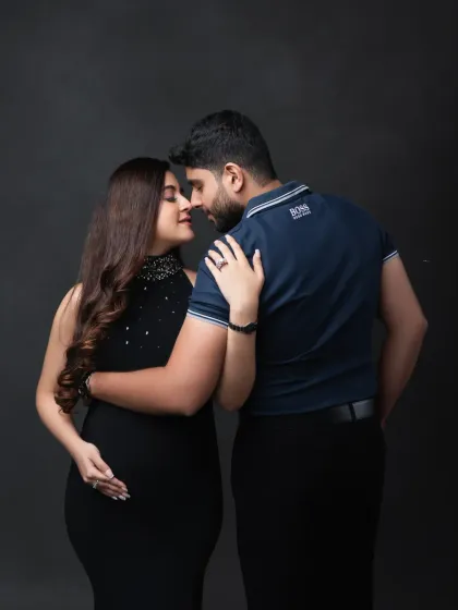 An intimate and modern couple's portrait. The close-up, nose-to-nose pose against a simple dark background creates a powerful and emotional image.