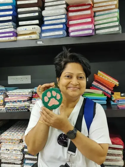 A participant proudly holds up her finished paw print coaster, a perfect gift for any pet lover.