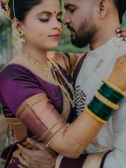 A close, loving embrace that highlights the bride's intricate jewelry and the groom's gentle hold. The focus is on their connection, creating a warm and romantic feel.