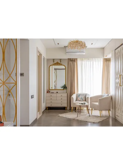 The cozy seating nook features two plush armchairs, a delicate coffee table, and a beautiful vanity. It’s the perfect corner for a morning coffee or quiet reading.