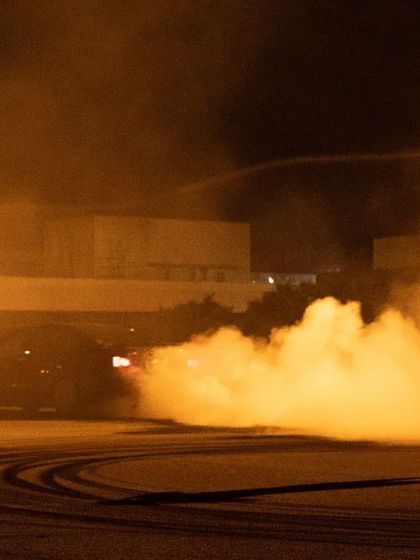 A silhouette of me in my element, standing in the thick of tire smoke during a night drift shoot. Capturing these moments requires being right in the action.