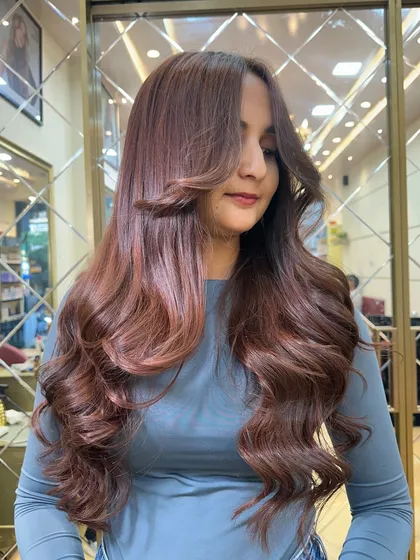 A beautiful profile shot of the Mocha Mousse color. The face framing layers and soft waves create a stunning, glamorous look.