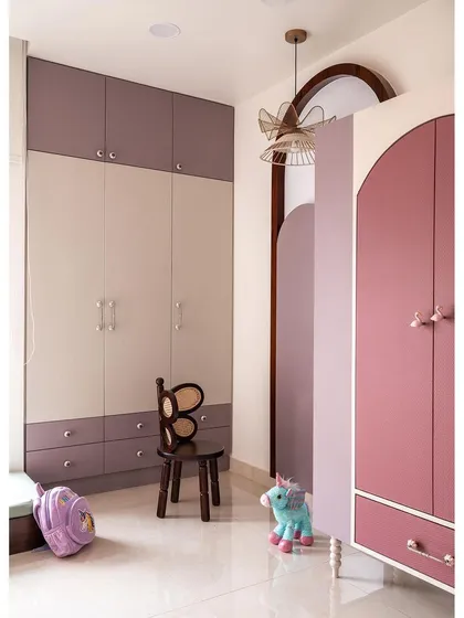 This shot showcases the clever storage solutions in the kids' bedroom. The wardrobes use a playful mix of pastel hues, while an arched, freestanding closet adds a whimsical touch.