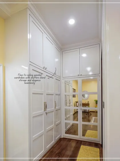 A view of the corridor from the bedroom in image 24, showing the floor-to-ceiling white paneled wardrobes.