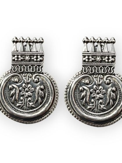 Nothing is more worth it than buying pure silver earrings. This pair of oxidised studs features intricate floral carvings in a traditional design.