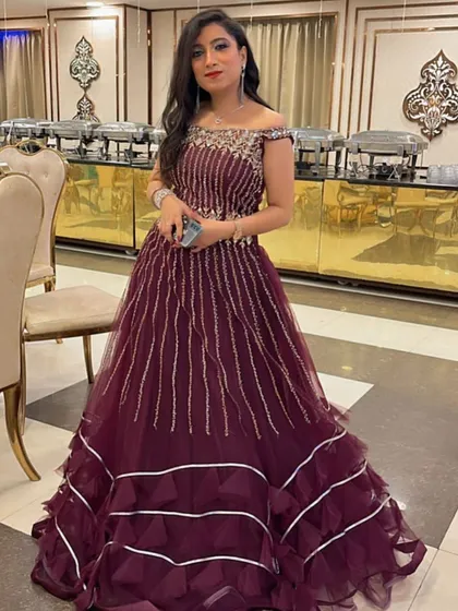 A rich wine-colored gown with a structured, tiered skirt and embellished bodice. This is a fantastic rental choice for a formal evening event or a winter wedding reception.