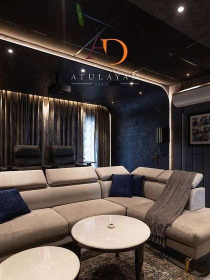 Another view of the home theatre, showing the dark, moody color palette and curved wall design that minimizes light reflection and enhances the viewing experience.