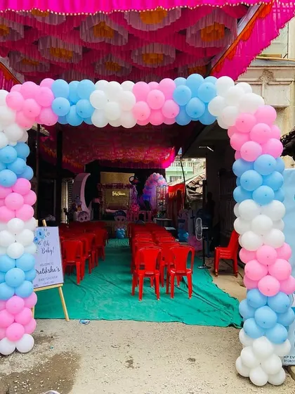 A classic pink, blue, and white balloon arch at the entrance of a baby shower, setting a festive tone.