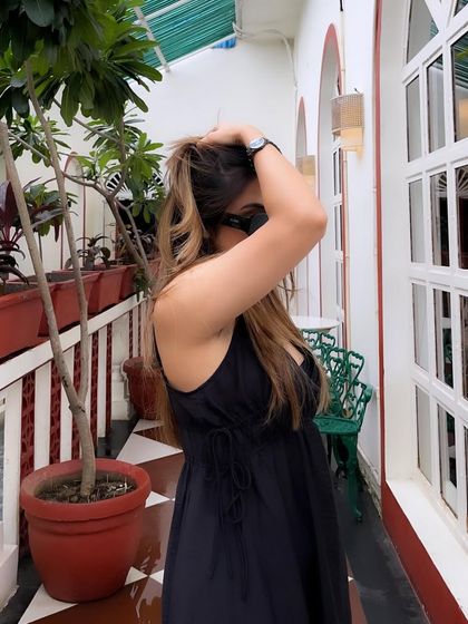 A candid moment adjusting my hair in the black maxi dress.